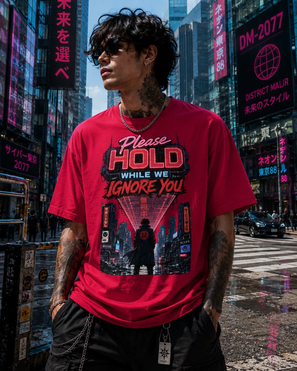 A man wearing a red graphic t-shirt with a cyberpunk-themed print that reads 'Please HOLD WHILE WE IGNORE YOU' and 'District Malir 88', standing in a busy city street with neon signs in the background.