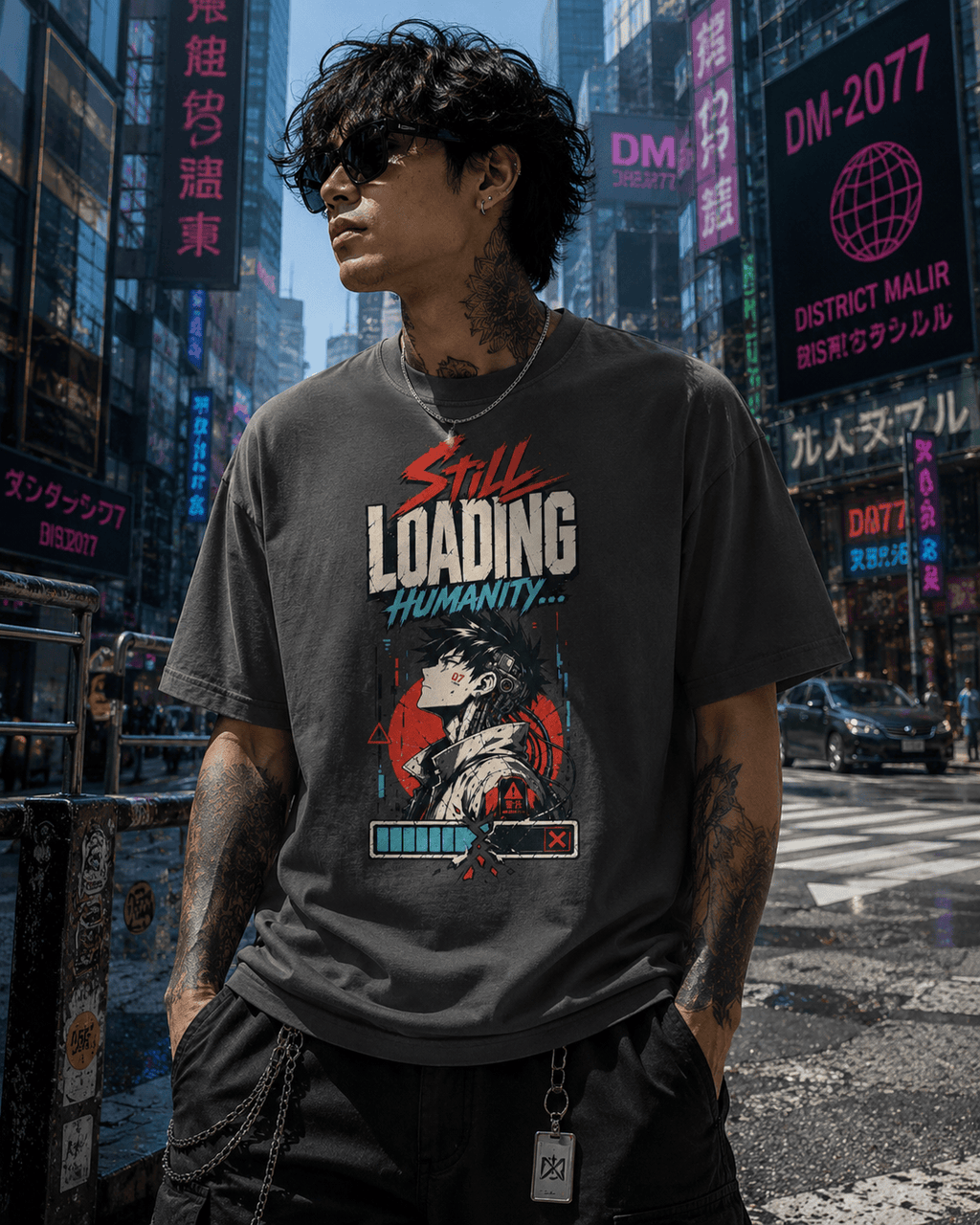 A man wearing a dark gray graphic t-shirt with a 'Still Loading Humanity.