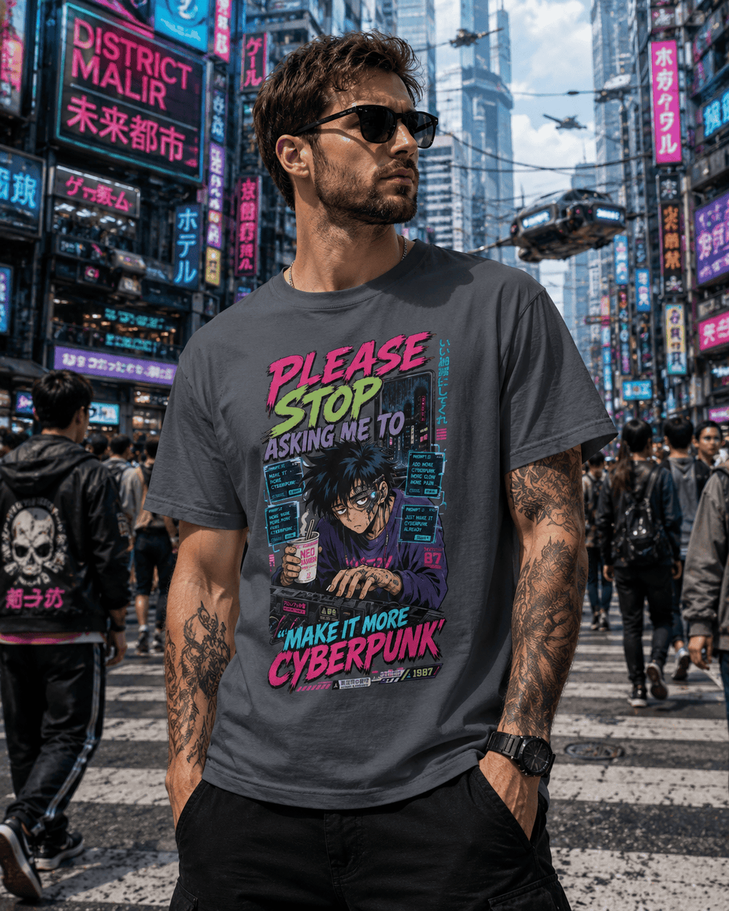 A man wearing a dark gray graphic t-shirt with a cyberpunk-themed print, standing in a busy neon-lit city street.